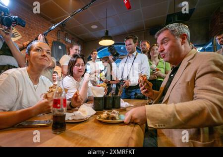 München, Deutschland. Juli 2024. Markus Söder (CSU), Ministerpräsident Bayerns, spricht mit geladenen Gästen in einem Dönerrestaurant. Söder hatte zuvor Kebabs an Instagram-Fans verlost. Quelle: Peter Kneffel/dpa/Alamy Live News Stockfoto