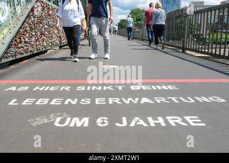 Spruch auf der Hohenzollernbrücke in Köln: Ab hier sinkt deine Lebenserwartung um 6 Jahre. Hinweis den Einfluss von Armut auf die Lebenserwartung. *** Slogan auf der Hohenzollernbrücke in Köln: Von hier aus sinkt Ihre Lebenserwartung um 6 Jahre. Hinweis auf den Einfluss der Armut auf die Lebenserwartung. Nordrhein-Westfalen Deutschland, Deutschland GMS16687 Stockfoto