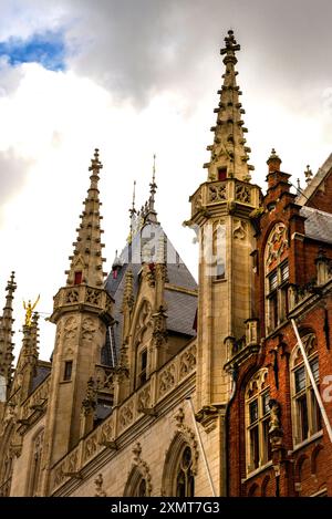 Seitenansicht des Rathauses im gotischen Stil und des Stufengiebels im gotischen Stil mit Tracery in Brügge, Belgien. Stockfoto