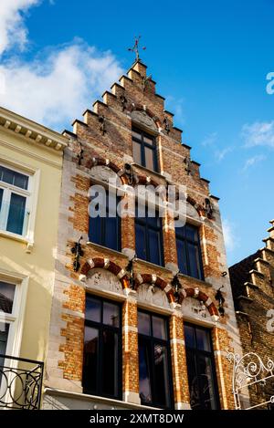 Ziegelstufengiebel und Fenstergiebel mit Relief in Brügge, Belgien. Stockfoto