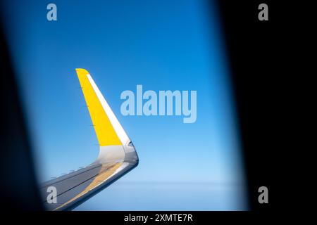 Horizontale Ansicht des gelben Flugzeugflügels von der Innenseite der Kabine Stockfoto