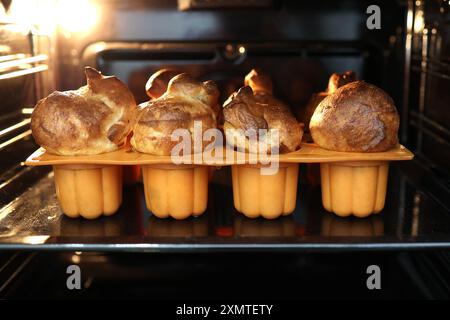 Hausgemachte Popover, eine üppige, luftige und Eierhohlrolle im Ofen. Yorkshire Pudding, frisch gebacken in Backformen, selektiver Fokus Stockfoto