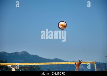 Ein actiongeladener Moment des 3x3 Ladeira Beach Volleyball Turniers in Baiona fängt einen Volleyball ein, der durch die Luft schwingt. Die dynamische Szene hoch Stockfoto