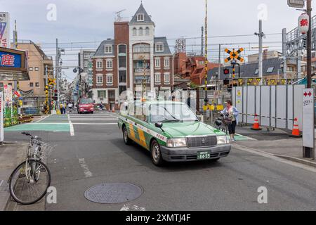 Nakano, Japan – 24. Mai 2024: Eisenbahnüberquerung in Nakano City, Tokio, Japan. Taxiwagen im Hintergrund Stockfoto