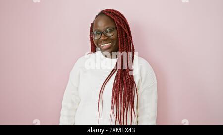 Lächelnde Frau mit Zöpfen, Brille, isoliert auf rosa Hintergrund Stockfoto