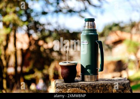 Yerba Mate Infusion typisch für Südamerika. Kürbisgefährte begleitet von der Stanley Thermos im Wald über einem Felsen. La Cumbrecita, Cordoba, Argen Stockfoto