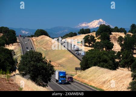 Blick auf Lkw und Verkehr, die entlang der interstate 5 im Tehama County Kalifornien fahren, mit dem dramatischen Kegel des Mount Shasta in der Ferne Stockfoto