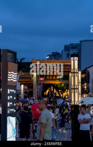 suzhou, China - 10. Juni 2024 : Eine belebte Straße in Suzhou, China, beleuchtet von leuchtenden Laternen und Straßenlaternen. Stockfoto