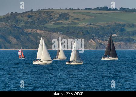 Weymouth, Dorset, Großbritannien. Juli 2024. Wetter in Großbritannien: Yachten unter Segeln in Weymouth Bay in Dorset fahren an einem warmen, sonnigen Abend. Bildnachweis: Graham Hunt/Alamy Live News Stockfoto