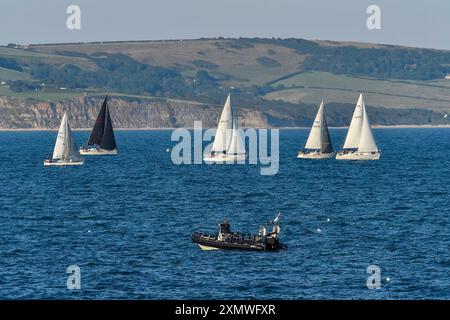 Weymouth, Dorset, Großbritannien. Juli 2024. Wetter in Großbritannien: Yachten unter Segeln in Weymouth Bay in Dorset fahren an einem warmen, sonnigen Abend. Bildnachweis: Graham Hunt/Alamy Live News Stockfoto