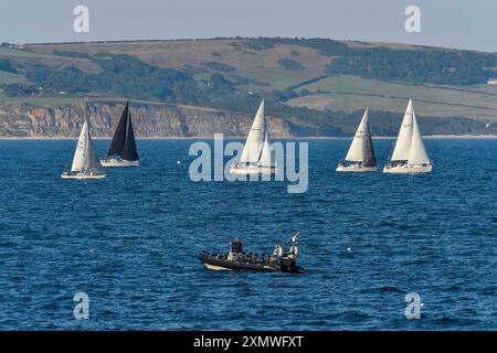 Weymouth, Dorset, Großbritannien. Juli 2024. Wetter in Großbritannien: Yachten unter Segeln in Weymouth Bay in Dorset fahren an einem warmen, sonnigen Abend. Bildnachweis: Graham Hunt/Alamy Live News Stockfoto