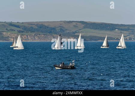 Weymouth, Dorset, Großbritannien. Juli 2024. Wetter in Großbritannien: Yachten unter Segeln in Weymouth Bay in Dorset fahren an einem warmen, sonnigen Abend. Bildnachweis: Graham Hunt/Alamy Live News Stockfoto