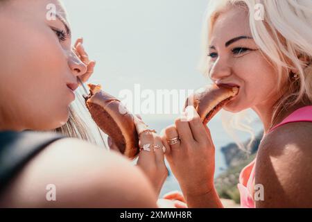 Zwei Frauen genießen einen Snack an einem sonnigen Tag Stockfoto