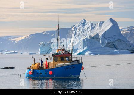 Fischerboot vor Eisbergen, sonnig, Uummannaq, Grönland Stockfoto