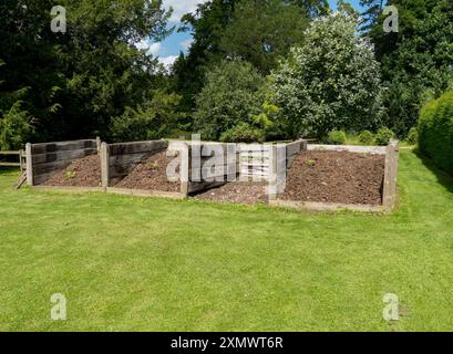 Große hölzerne Gartenkompostbehälter aus alten Eisenbahnschwellen, Easton Walled Gardens, Grantham, England, Großbritannien Stockfoto