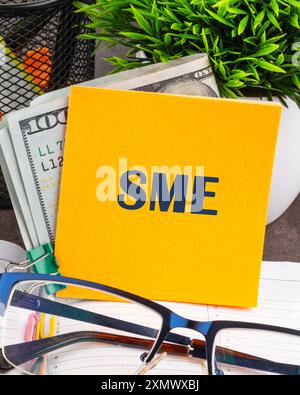 Word SME. Small and medium-sized enterprises - commercial enterprises. The SME symbol on a yellow sticker on the table Stockfoto