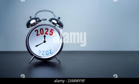 2024 und 2025 auf weißem Wecker auf schwarzem Tisch mit Kopierraum zur Vorbereitung des Konzepts „Frohe Weihnachten und Happy New Year“. Beginnen Sie ein neues Geschäft, S Stockfoto