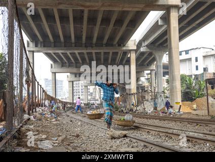 Ein Mann aus bangladesch trägt Körbe entlang der Schiene, Dhaka Division, Dhaka, Bangladesch Stockfoto