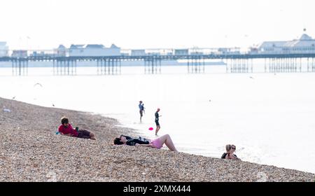 Brighton UK 30 Juli 2024 - am frühen Morgen genießen Besucher am Brighton Beach den heißen Sonnenschein wie heute prognostiziert wird der heißeste Tag des Jahres bisher mit Temperaturen von über 30 Grad in einigen Teilen des Südostens : Credit Simon Dack / Alamy Live News Stockfoto