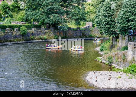 La Roche-en-Ardenne, Belgien. Juni 2024. Touristen in drei aufblasbaren Ruderbooten segeln auf dem Fluss Ourthe, Steinmauern und grünen Bäumen, genießen einen Stockfoto