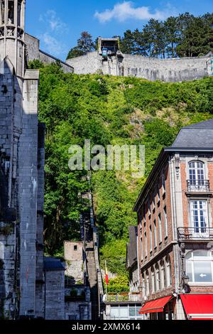 Seilbahn, die in Richtung Dinant-Stadt hinauf oder hinunter führt, Eingang zu einer Treppe, die zur Zitadelle im Hintergrund führt, grüne Vegetation und grüne Bäume, sonnige Sommerzeit Stockfoto