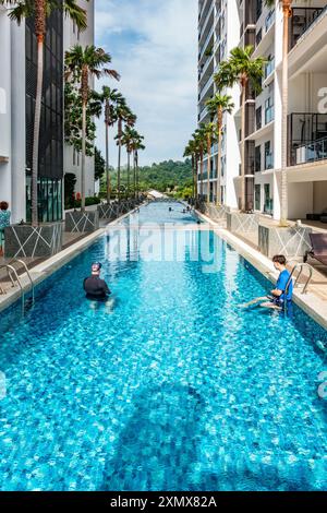 Die Gäste schwimmen im Swimmingpool eines Appartementhauses in Penang, Malaysia. Stockfoto