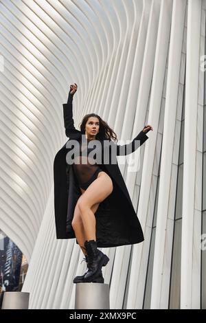 Die junge Frau tanzt anmutig in den Straßen von New York, eingerahmt von moderner Architektur. Stockfoto