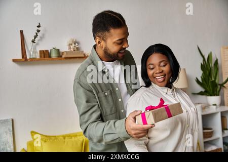 Ein Mann schenkt einer Frau zu Hause ein Geschenk. Stockfoto