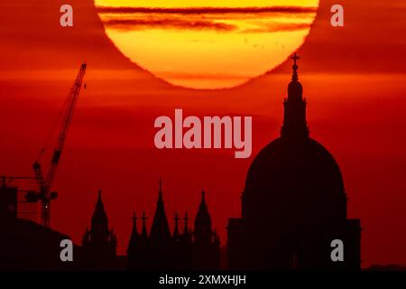 London, Großbritannien. 30. Juli 2024. Wetter in Großbritannien: Hitzewellen-Sonnenuntergang über St. Paul's Cathedral endet einen warmen Dienstag. Das Vereinigte Königreich hat möglicherweise seinen bisher heißesten Tag des Jahres, da die Temperaturen heute voraussichtlich über 30 °C (86 °F) liegen werden. Guy Corbishley/Alamy Live News Stockfoto