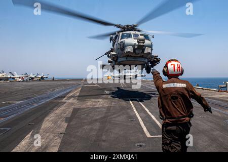 US 5TH FLEET AREA OF OPERATIONS (25. Juli 2024) ein Aviation Machinist’s Mate leitet einen MH-60R Sea Hawk Hubschrauber, der an Helicopter Maritime befestigt ist Stockfoto