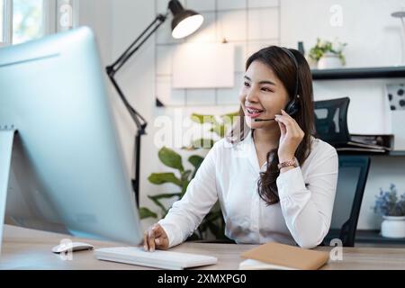 Professioneller Callcenter-Agent, der am Schreibtisch mit Headset in moderner Büroumgebung arbeitet Stockfoto