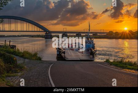 Landschaft von Culemborg bei Sonnenuntergang, Blick auf die Brücke über den Lek River und Überfahrt mit der Fähre Stockfoto