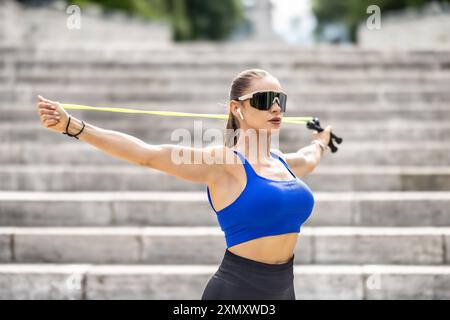 Außenaufnahme einer Frau in Sportbekleidung, die draußen in einem Park mit Seilspringen trainiert. Fitnesstraining-Frau mit Sprungseil in einem Park. Stockfoto