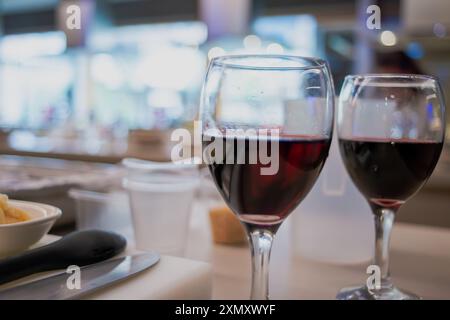Ein Blick auf eine Sushi-Werkstattküche mit einem Glas Wein, die die Mischung aus kulinarischer Zubereitung mit einem eleganten Hauch Wein hervorhebt Stockfoto