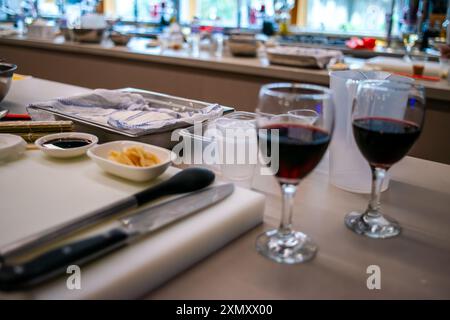 Ein Blick auf eine Sushi-Werkstattküche mit einem Glas Wein, die die Mischung aus kulinarischer Zubereitung mit einem eleganten Hauch Wein hervorhebt Stockfoto