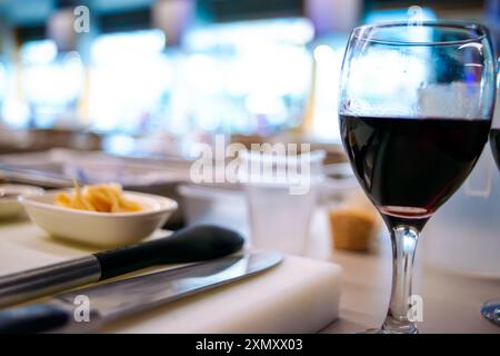 Ein Blick auf eine Sushi-Werkstattküche mit einem Glas Wein, die die Mischung aus kulinarischer Zubereitung mit einem eleganten Hauch Wein hervorhebt Stockfoto
