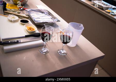 Ein Blick auf eine Sushi-Werkstattküche mit einem Glas Wein, die die Mischung aus kulinarischer Zubereitung mit einem eleganten Hauch Wein hervorhebt Stockfoto