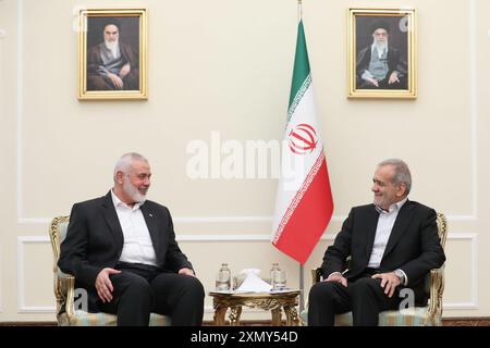 Teheran, Iran. 30. Juli 2024. Der neue iranische Präsident MASOUD PEZESHKIAN (R) trifft in Teheran auf den Hamas-Chef ISMAEIL HANIYEH (L). Porträts an der Wand zeigen den Obersten Führer des Iran, Ayatollah Ali Khamenei (R), und seinen Vorgänger, den späten Gründer der Islamischen Republik, Ayatollah Ruhollah Khomeini. (Credit Image: © Iranian Presidency via ZUMA Press Wire) NUR REDAKTIONELLE VERWENDUNG! Nicht für kommerzielle ZWECKE! Quelle: ZUMA Press, Inc./Alamy Live News Stockfoto