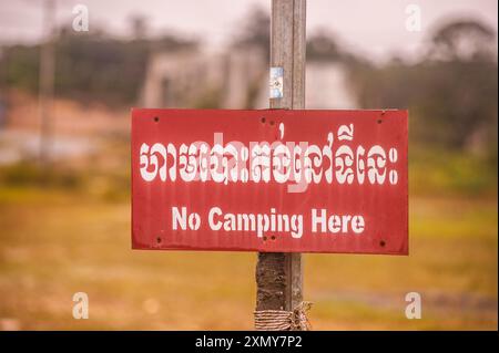 Zweisprachiges Schild mit der Aufschrift „No Camping here“. Popokvil Wasserfall. Bokor Mountain, Preah Monivong Bokor National Park, Provinz Kampot, Kambodscha. © Kraig Lieb Stockfoto