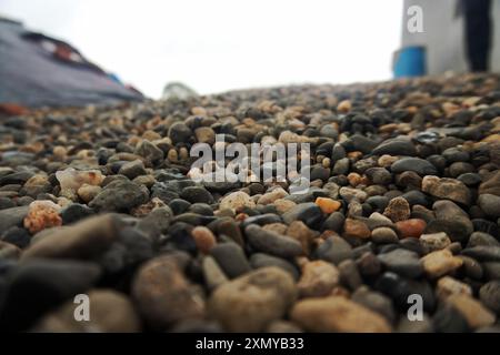 Tauchen Sie ein in die Schönheit der Natur mit diesem Stockbild, das eine dichte Auswahl an bunten Kieselsteinen zeigt. Verwenden Sie sie für Texturüberlagerungen oder als e Stockfoto
