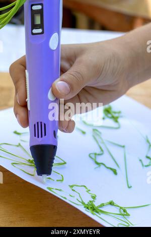 Kinderhand erstellt Figuren mit einem 3D-Stift. Nahaufnahme. Stockfoto