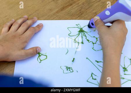 Kinderhände erstellen Figuren mit 3D-Stift. Nahaufnahme. Draufsicht. Stockfoto