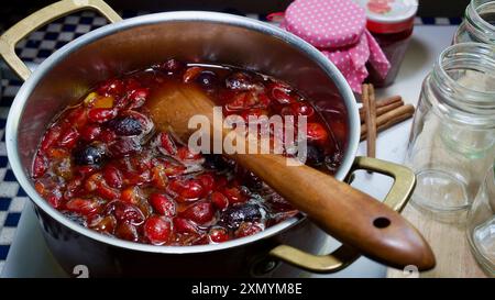 Pflaumen in einem Kochtopf, ein Holzlöffel. Hausgemachte Marmelade. Stockfoto