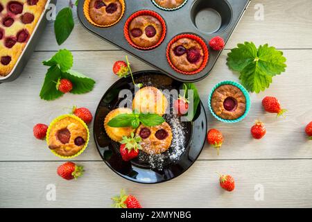 Süße Quark-Muffins mit Erdbeerfüllung, auf einem Teller auf einem Holztisch. Stockfoto