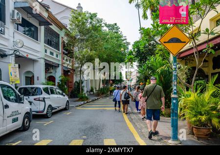 Menschen laufen entlang der Armenian Street, einer von Bäumen gesäumten Straße in George Town, Penenag, Malaysia Stockfoto