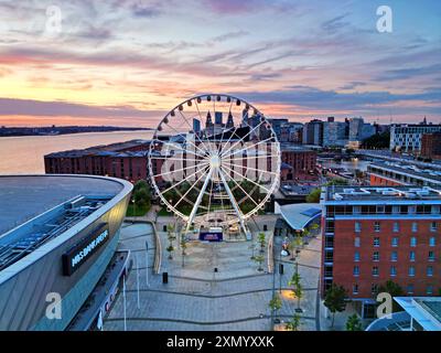 Blick aus der Vogelperspektive auf das Rad von Liverpool mit Albert Dock und Gebäuden am Wasser im Hintergrund bei Dämmerung. Stockfoto