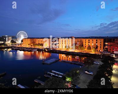 Aus der Vogelperspektive auf die Gebäude des Royal Albert Dock Liverpool und das große Rad in der Abenddämmerung. Stockfoto