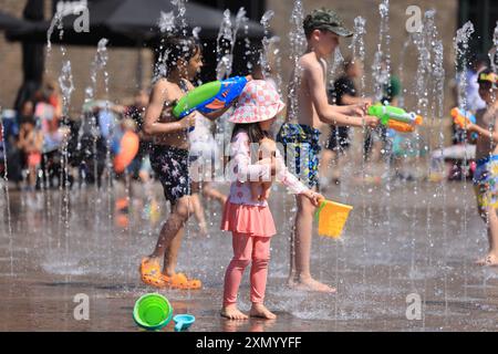 London, UK, 30. Juli 2024. Kinder halten sich in den Springbrunnen am Granary Square, Kings Cross, Nord-London, kühl. Dienstag sollte mit 32 Grad der heißeste Tag des Jahres sein, da eine Hitzewelle große Teile Großbritanniens betrifft. Es wird aber nicht lange dauern, denn Gewitter werden für später in der Woche vorhergesagt. Kredit : Monica Wells/Alamy Live News Stockfoto