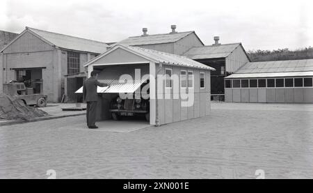 1950er Jahre, historisch, Mann, Fertiggarage, Auto der Ära innen, Oxford, England, Großbritannien. Stockfoto