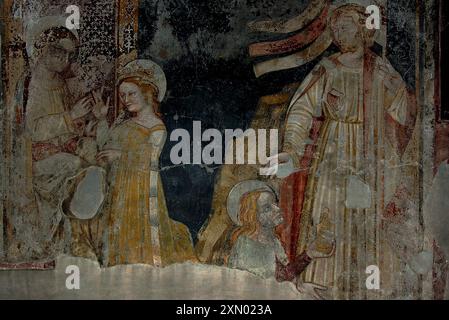 Maria Magdalena (unten rechts) im spätmittelalterlichen Fresko in der Basilika-Duomo di San Vigil in Trient, Italien. Maria wird dargestellt, die ein Salbenglas oder eine Parfümflasche hält, während sie zu den Füßen Jesu kniet. Stockfoto